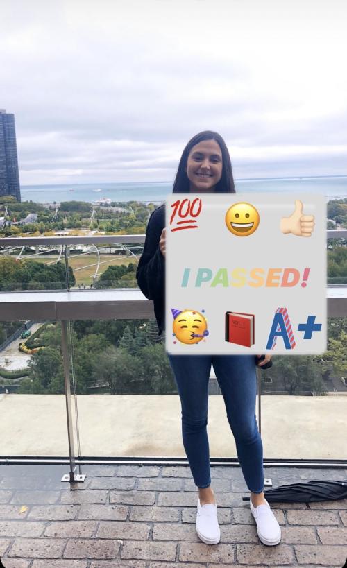 Elizabeth Schleifer holding a sign that says "I Passed"